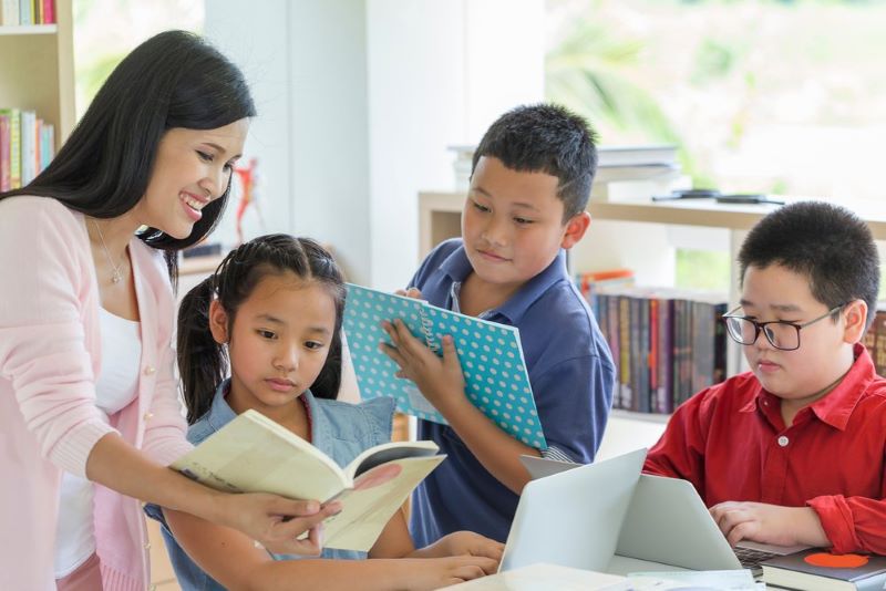 Ilustrasi seorang guru dan siswa sedang membaca buku. (Parentalk.id)
