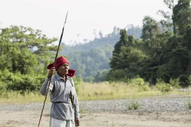 Seorang pria Hongana Manyawa di tepi sungai di hutan hujan Halmahera. (Nanang Sujana/Survival Internasional)