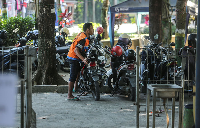 TERTATA: Juru parkir merapikan motor di Kawasan Lapangan Denggung, Sleman (10/8). ELANG KHARISMA DEWANGGA/RADAR JOGJA