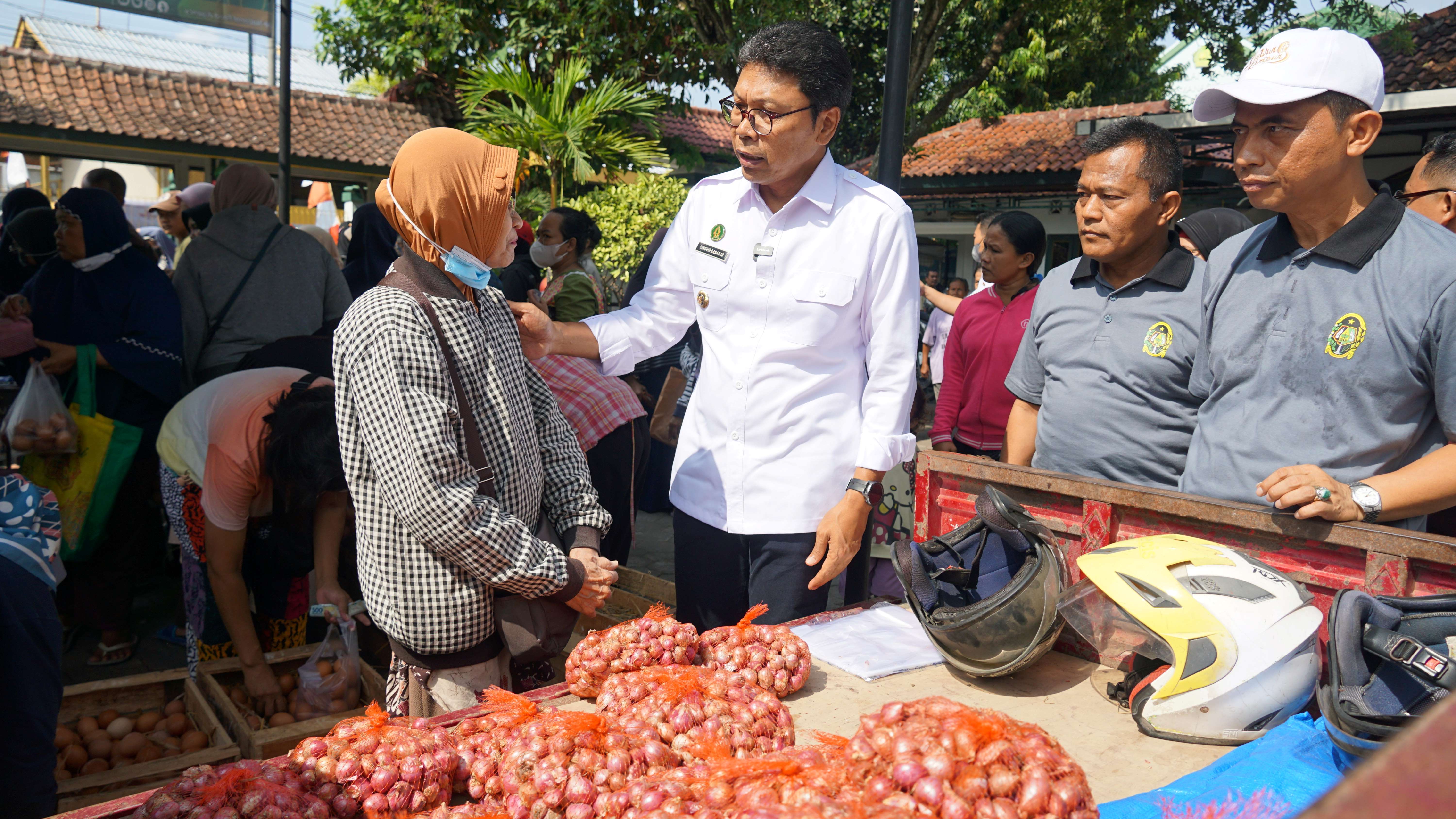 DIALOG: Penjabat Wali Kota Jogja Singgih Raharjo berbincang dengan salah satu warga yang membeli bahan pangan bawang merah pada kegiatan Gerakan Pangan Murah di Kemantren Kotagede.