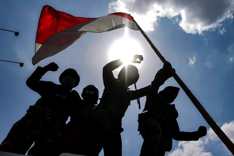 Sejumlah warga dari komunitas Sepeda Onthel, FKPPI, Relawan Republik Aeng-Aeng menggelar aksi kibarkan merah putih di Jembatan Keris Kali Anyar, Kelurahan Gilingan, (10/11). (Damianus Bram/Radar Solo)