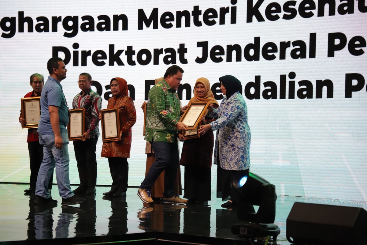 TERBAIK: Dirjen Pencegahan dan Pengendalian Penyakit Kemenkes RI Maxi Rein Rondonuwu menyerahkan penghargaan ke Plt Bupati Purworejo dalam puncak peringatan HKN ke-59 di Jakarta Sabtu (11/11). (Ist)