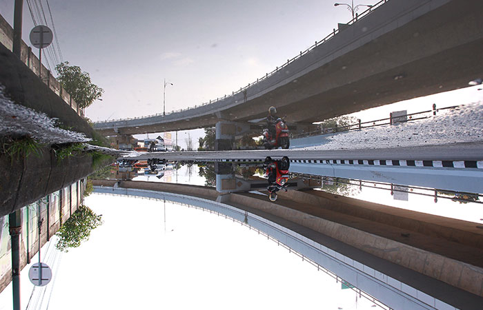 HARUS WASPADA: Pengendara kendaraan bermotor melintas di dekat genangan air hujan di kawasan Flyover Jombor Minggu (12/11). GUNTUR AGA TIRTANA/RADAR JOGJA
