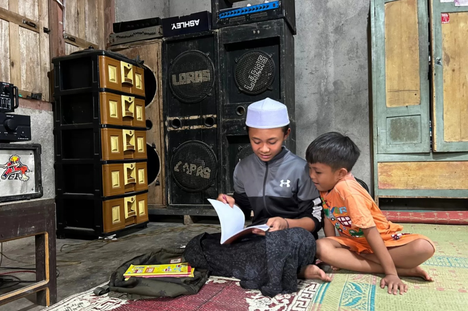 Bayu M. Ridlo, penerima beasiswa Program Indonesia Pintar (PIP), tengah belajar bersama adiknya di rumahnya, di daerah Samigaluh, Kulon Progo, Jogjakarta. (Istimewa)