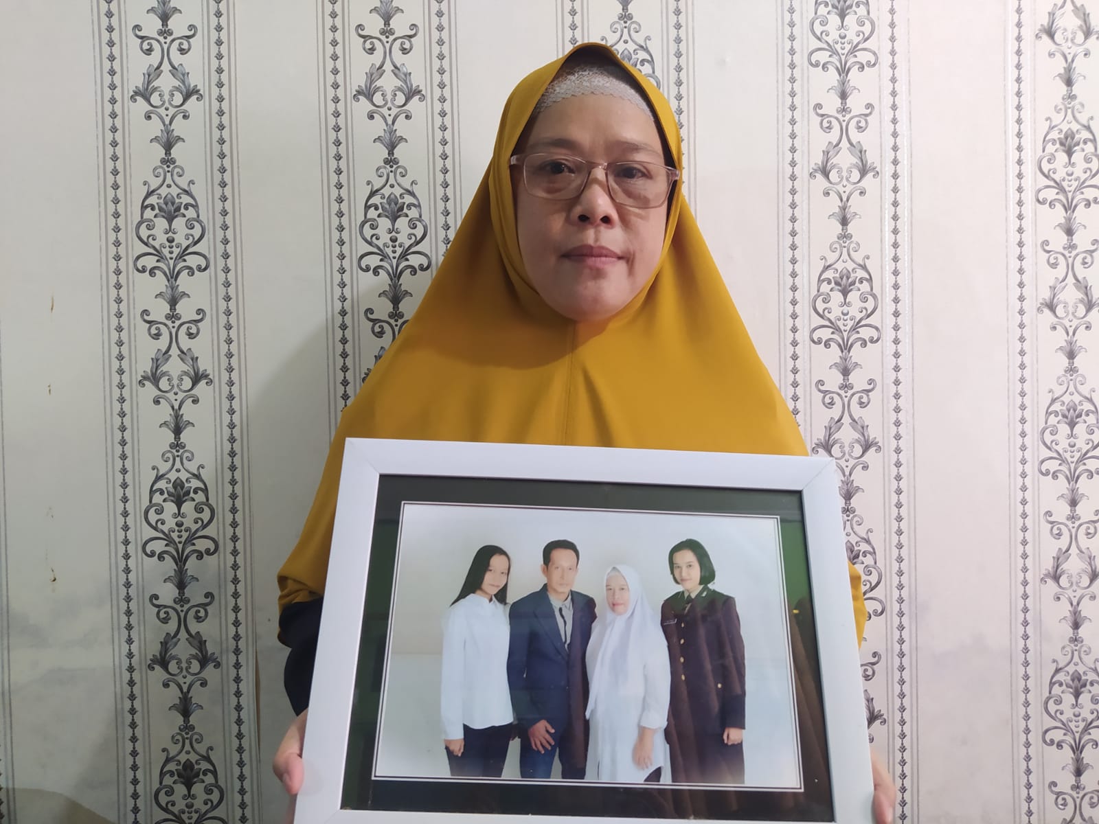 BERPRESTASI: Ibu dari Briptu Renita Rismayanti, Melita tengah menunjukkan foto keluarga. Dia terakhir berhubungan dengan Renita melalui sambungan telepon Minggu (19/11). (Naila Nihayah/Radar Jogja)
