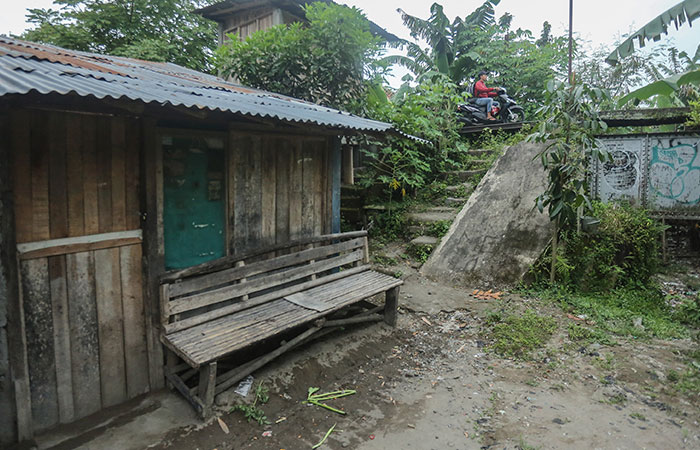 SESUAI FAKTA: Warga melintas berlatar rumah tidak huni layak di pinggir sungai Winongo di kawasan Panggungharjo, Sewon (16/1). Saat ini Dinsos Bantul tengah berupaya memperbaiki data penerima bantuan