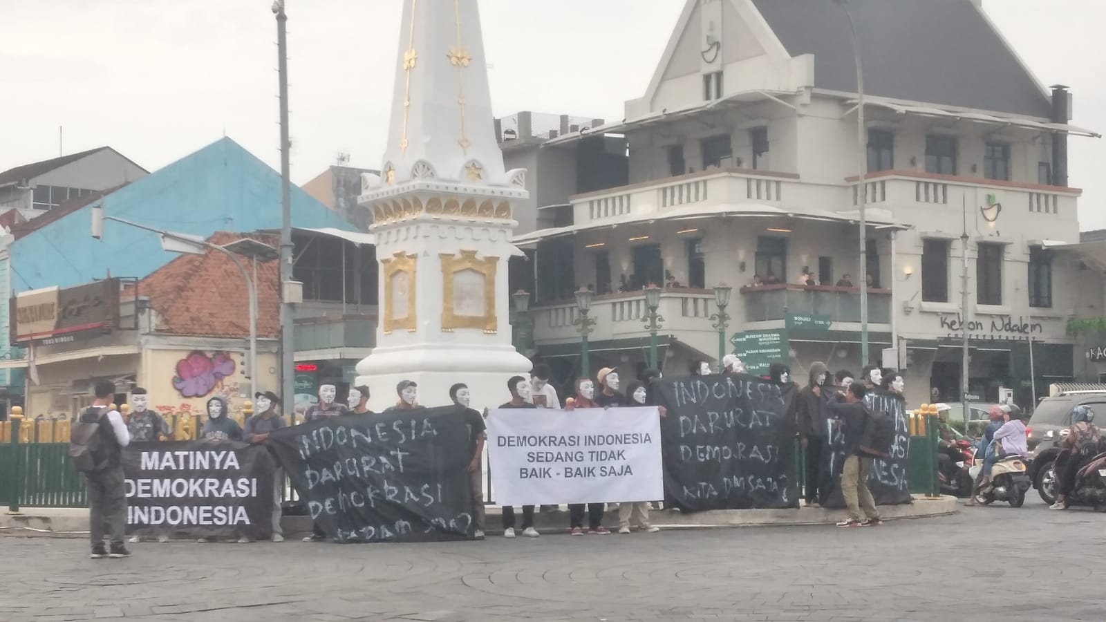 Massa aksi saat menggelar demonstrasi dengan mengenakan topeng Anonymous di Tugu Jogja