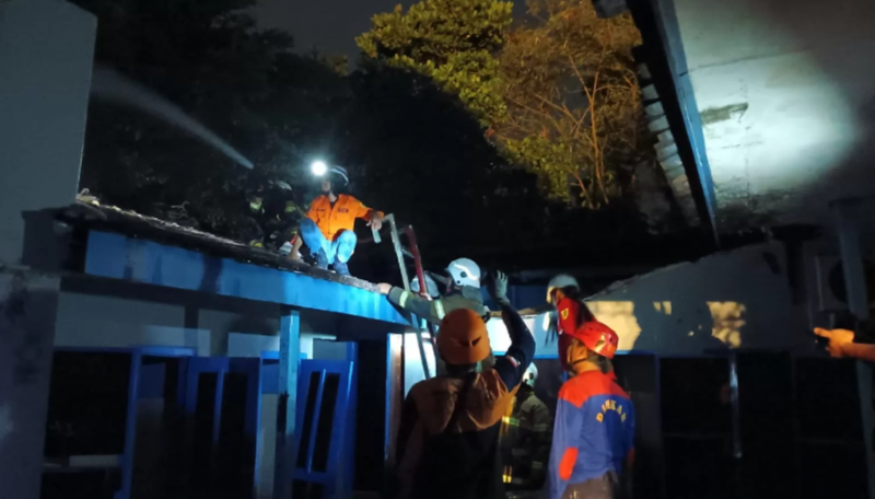 Petugas Damkar Klaten memastikan tidak titik api yang membakar gedung SMPN 1 Ceper, Klaten padam total, Senin (27/11/2023) malam. (ANGGA PURENDA/RADAR SOLO)