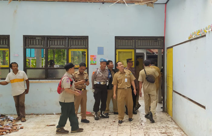 GOTONG ROYONG : Guru bersama warga membersihkan puing material atap bangunan SDN 1 Pejagatan yang ambruk pasca diguyur hujan semalam ISTIMEWA