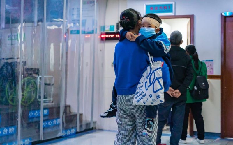 Potret ibu menggendoong anaknya yang terjangkit virus pneumonia. (Google/@BBC)