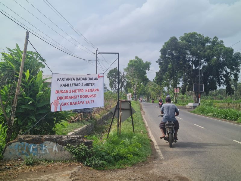 Warga Dusun Curah Lor kembali pasang spanduk sebagai bentuk aspirasi. Mereka ingin jalan penghubung antardusun itu diperlebar dan ditinggikan. (Naila Nihayah/Radar Jogja)