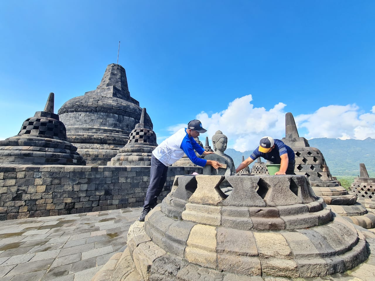 RERESIK: Para pekerja  membersihkan bebatuan candi dari lumut maupun mikroorganisme lain. Ini berlaku baik secara kering maupun basah. (Naila Nihayah/Radar Jogja)
