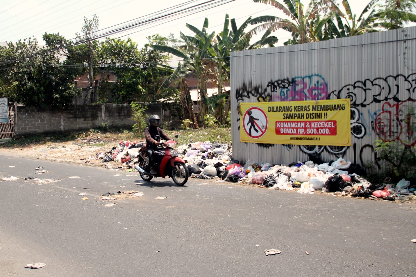 KOTOR: Pengendara melintas di depan tumpukan sampah liar di Jalan Bugisan Selatan, Tirtonirmolo, Kasihan, Bantul. (Gregorius Bramantyo/Radar Jogja)