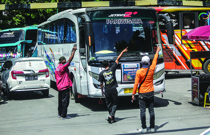 PANEN: Petugas parkir mengarahkan bus menuju tempat kosong di Parkiran Senopati, Gondomanan, Jogja.