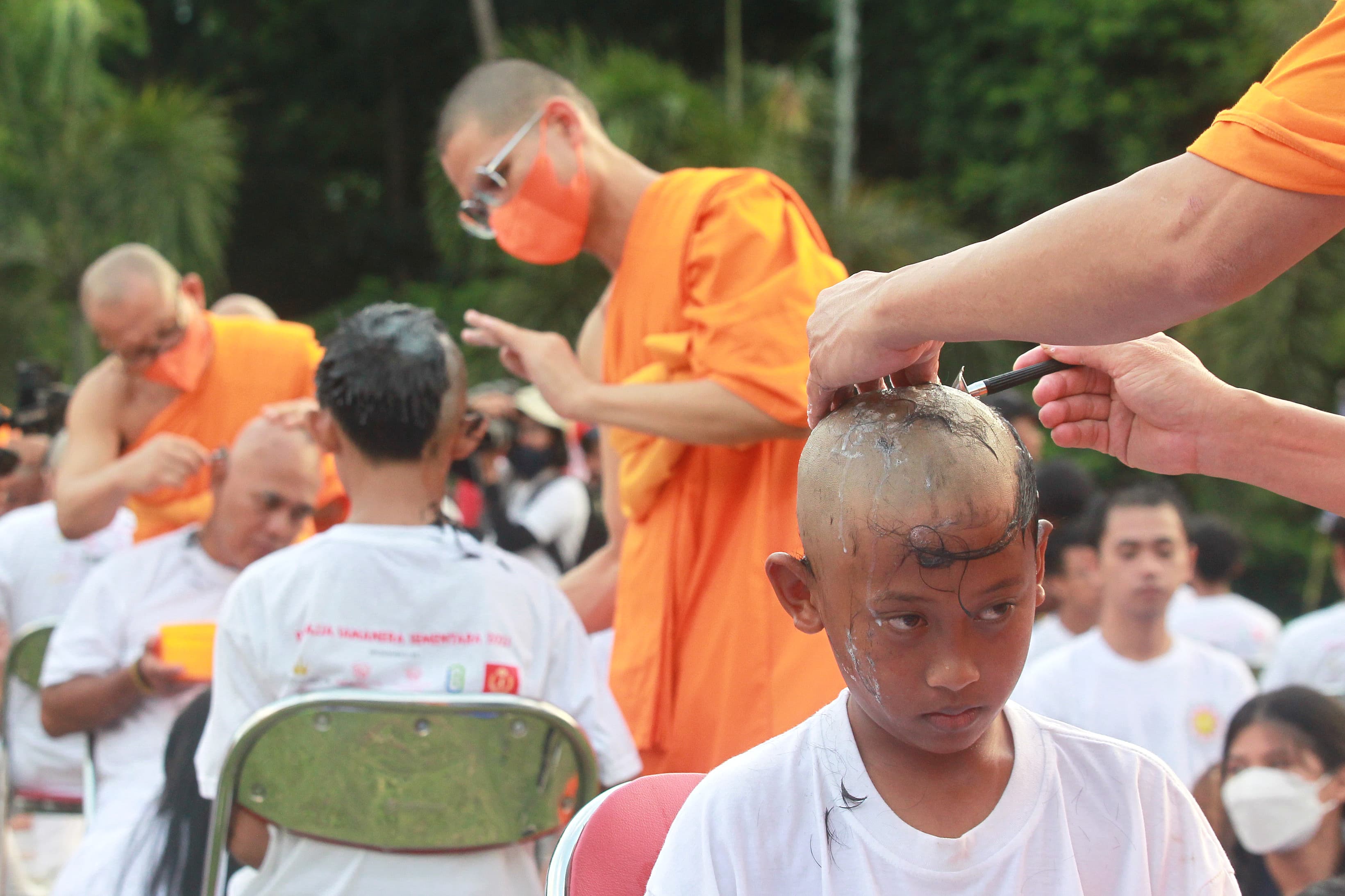 CALON BIKSU: Bikkhu mencukur rambut calon Samanera (bikkhu kecil) dalam ritual potong rambut rangkaian dari upacara Pabbajja Samanera di Taman Aksobya, kompleks Candi Borobudur, Magelang, Jawa Tengah,