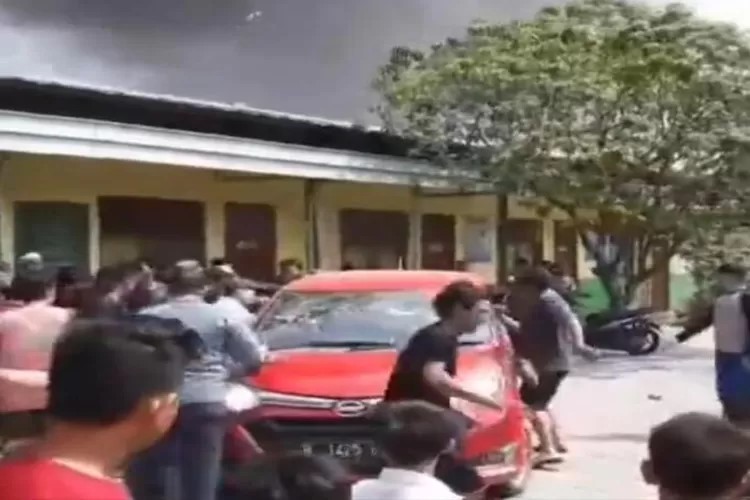 Warga menyingkirkan mobil yang menghadang mobil damkar. (Instagram @memoemedia)