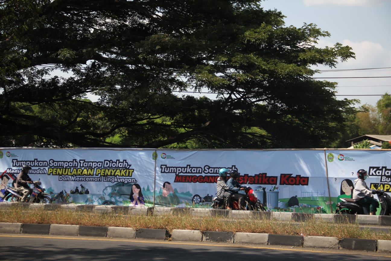 EFEKTIF?: Pengendara melintas di depan spanduk imbuan larangan pembuangan sampah liar di Ringroad Selatan, Wojo, Bangunharjo, Sewon. (Gregorius Bramantyo/Radar Jogja)