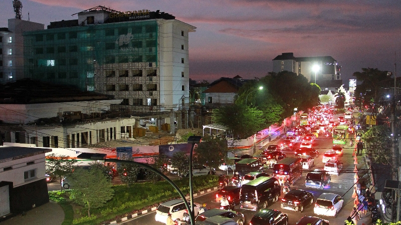 TINGGI: Kendaraan melintas di jalan raya dekat sebuah hotel di Jogja saat libur Natal. (Guntur Aga Tirtana/Radar Jogja)