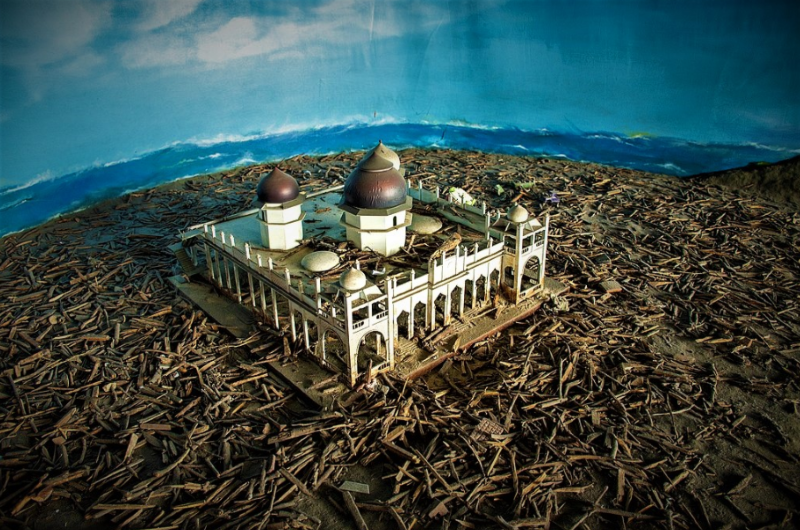 Diorama Masjid Ramatullah yang masih berdiri kokoh di antara puing-puing bangunan pasca dihujam Tsunami Aceh. (tangkapan layar/goodnewsfromindonesia.id)