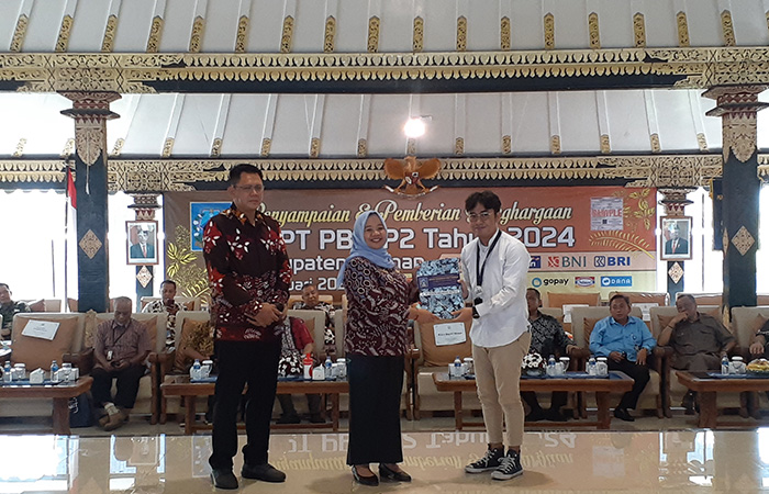 SIMBOLIS: Bupati Sleman Kustini Sri Purnomo saat memberikan apresiasi kepada wajib pajak dalam kegiatan Penyampaian SPPT PBB-P2 di Pendopo Parasamya Pemkab Sleman kemarin (2/1).