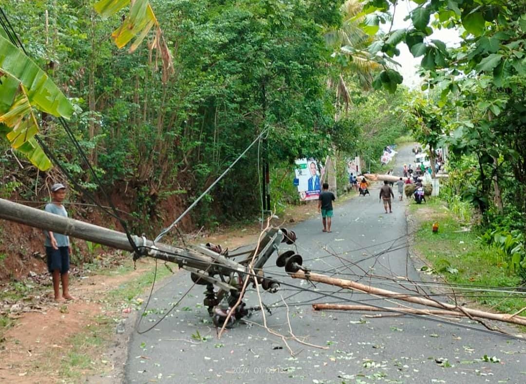 BERSIHKAN: Jajaran Polsek Dlingo dan sejumlah pihak mengevakuasi pohon dan tiang listrik yang roboh di Jalan Patuk-Dlingo, Bantul, Rabu (3/1). (Dok. Polres Bantul)