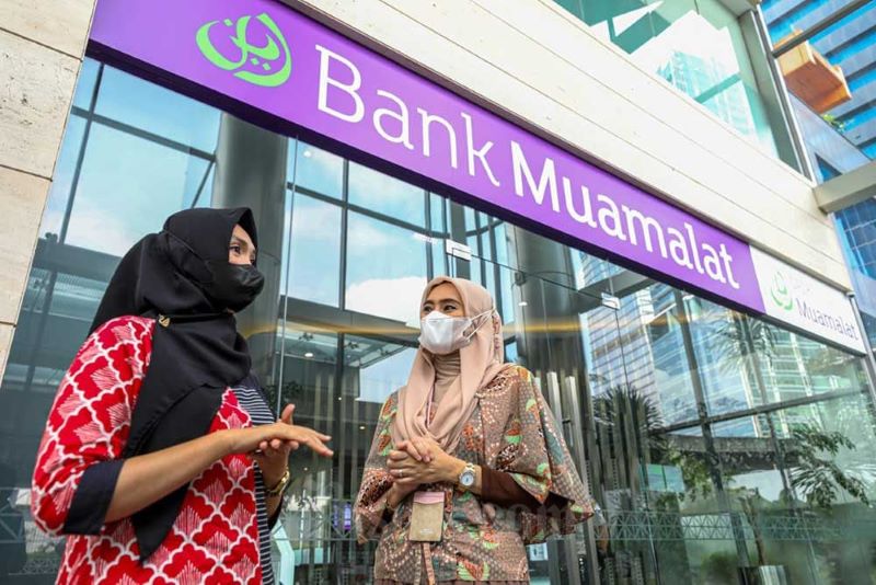 Dua perempuan sedang berbincang di depan salah satu gedung Bank Muamalat. (finansial.bisnis.com)