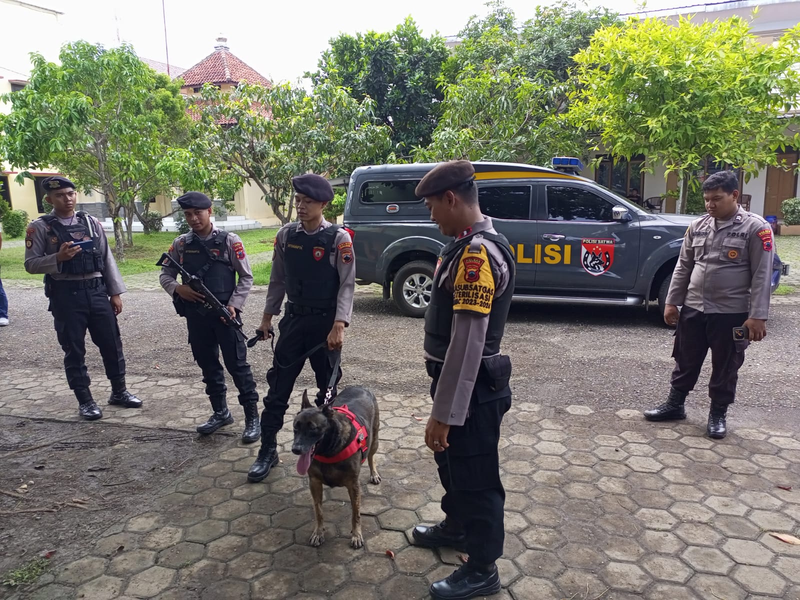PENGAMANAN: Personel Sat Samapta Polres Kebumen melibatkan anjing K-9 dalam proses sterilisasi gedung sortir lipat suara Pemilu 2024. (M HAFIED/RADAR KEBUMEN)