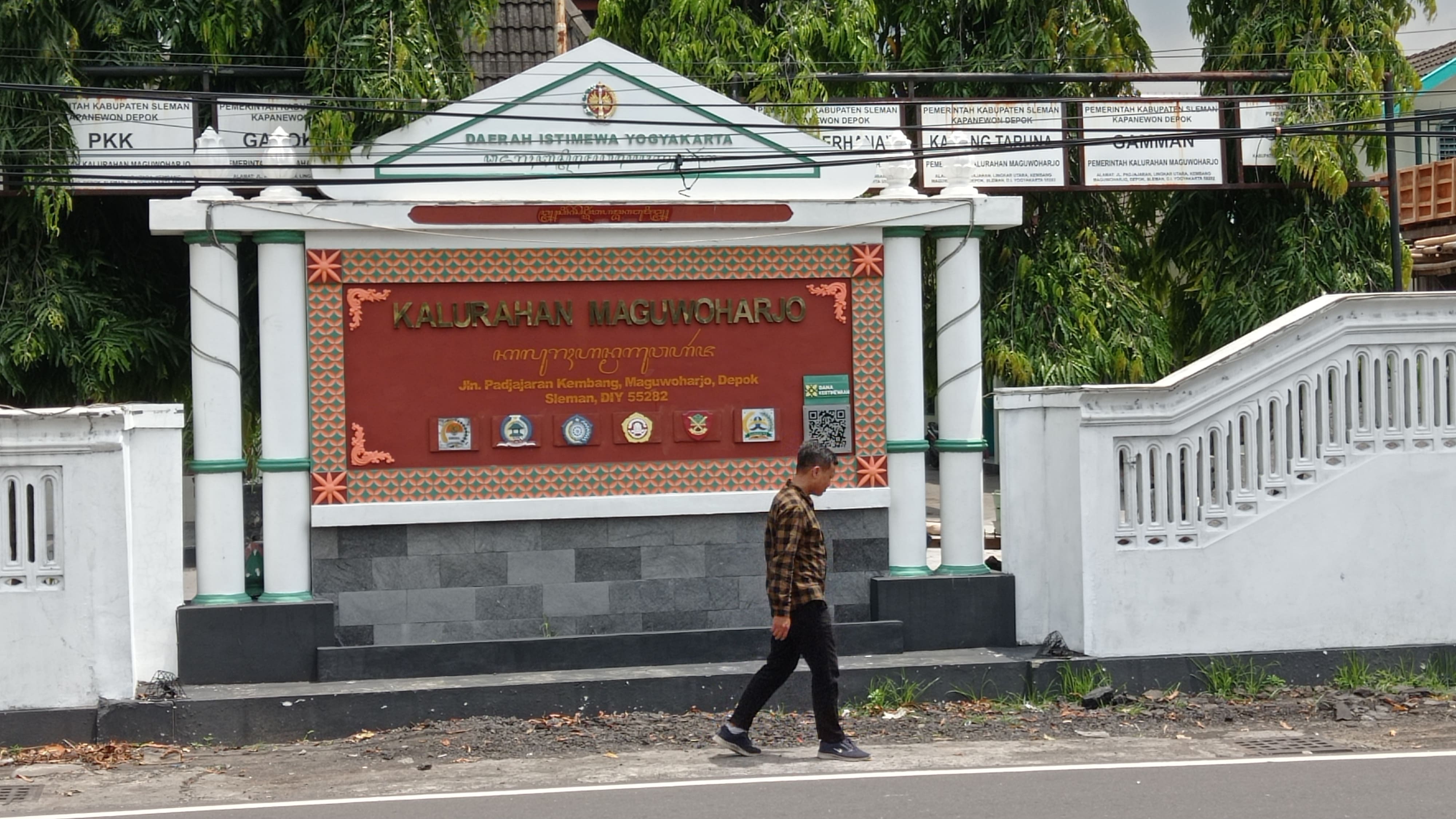 Warga melintas di depan kantor Kalurahan Maguwoharjo