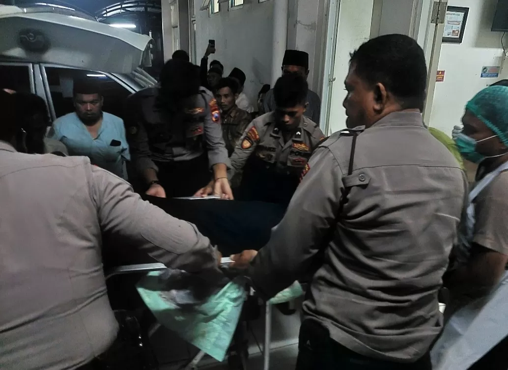 KAWAL KETAT: Petugas keamanan Polres Bangkalan mengeluarkan mayat korban dari ambulan di RSUD Syamrabu Bangkalan pada Jumat (12/1) malam.