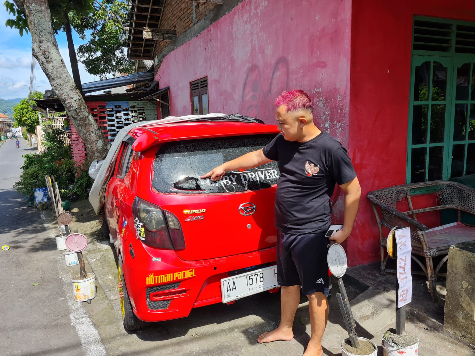 PECAH: Warga Jurangombo Selatan Zakaria memperlihatkan kaca mobil belakangnya yang pecah akibat dirusak oleh para pelaku kejahatan jalanan pada Minggu dini hari (14/1/2024).