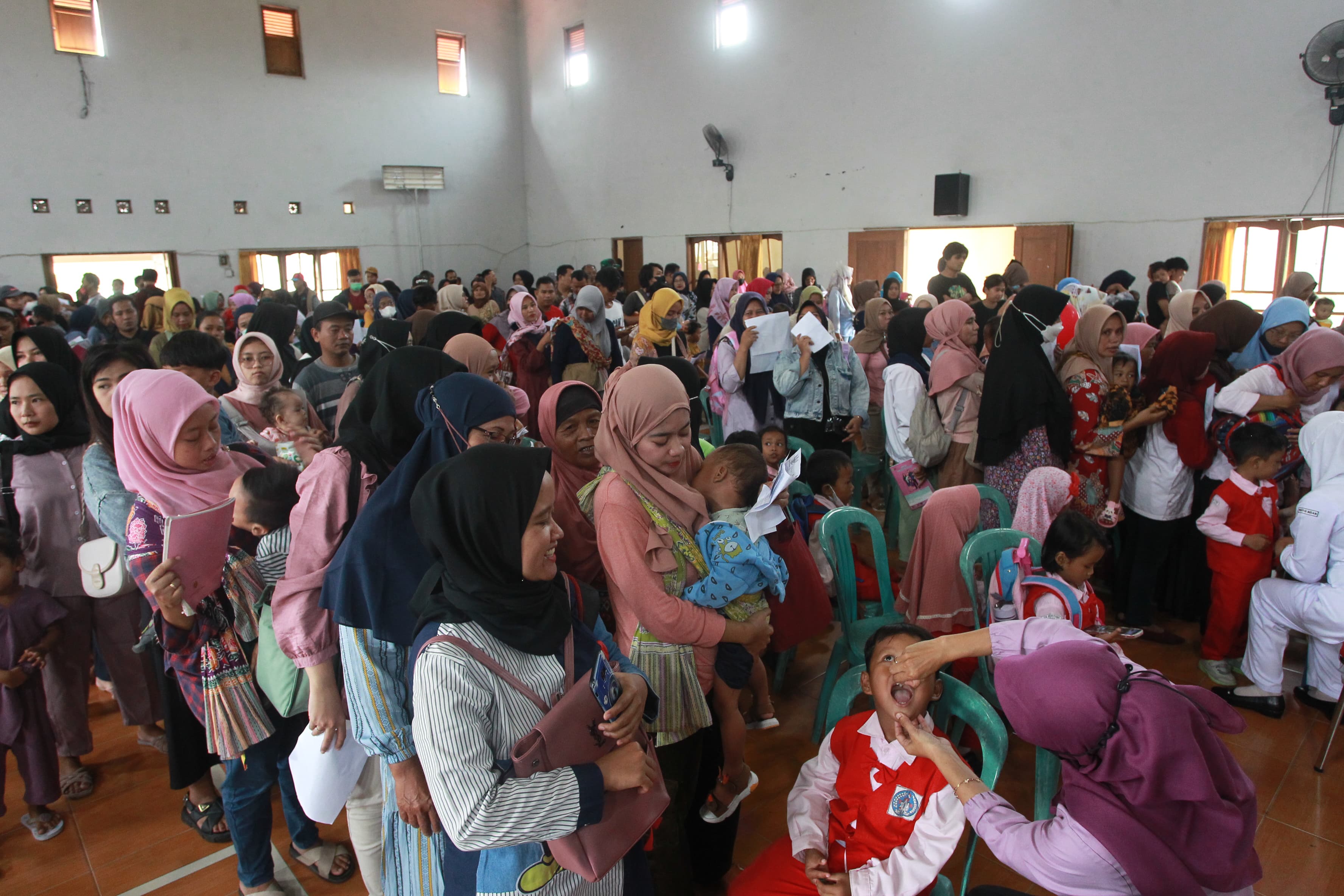 MEMBLUDAK: Suasana antrean yang mengular pada kegiatan Sub-PIN Polio di Kalurahan Caturharjo, Sleman, Senin (15/1). Dinkes Sleman menarget capaian imunisasi  bisa mencapai angka 99 persen.