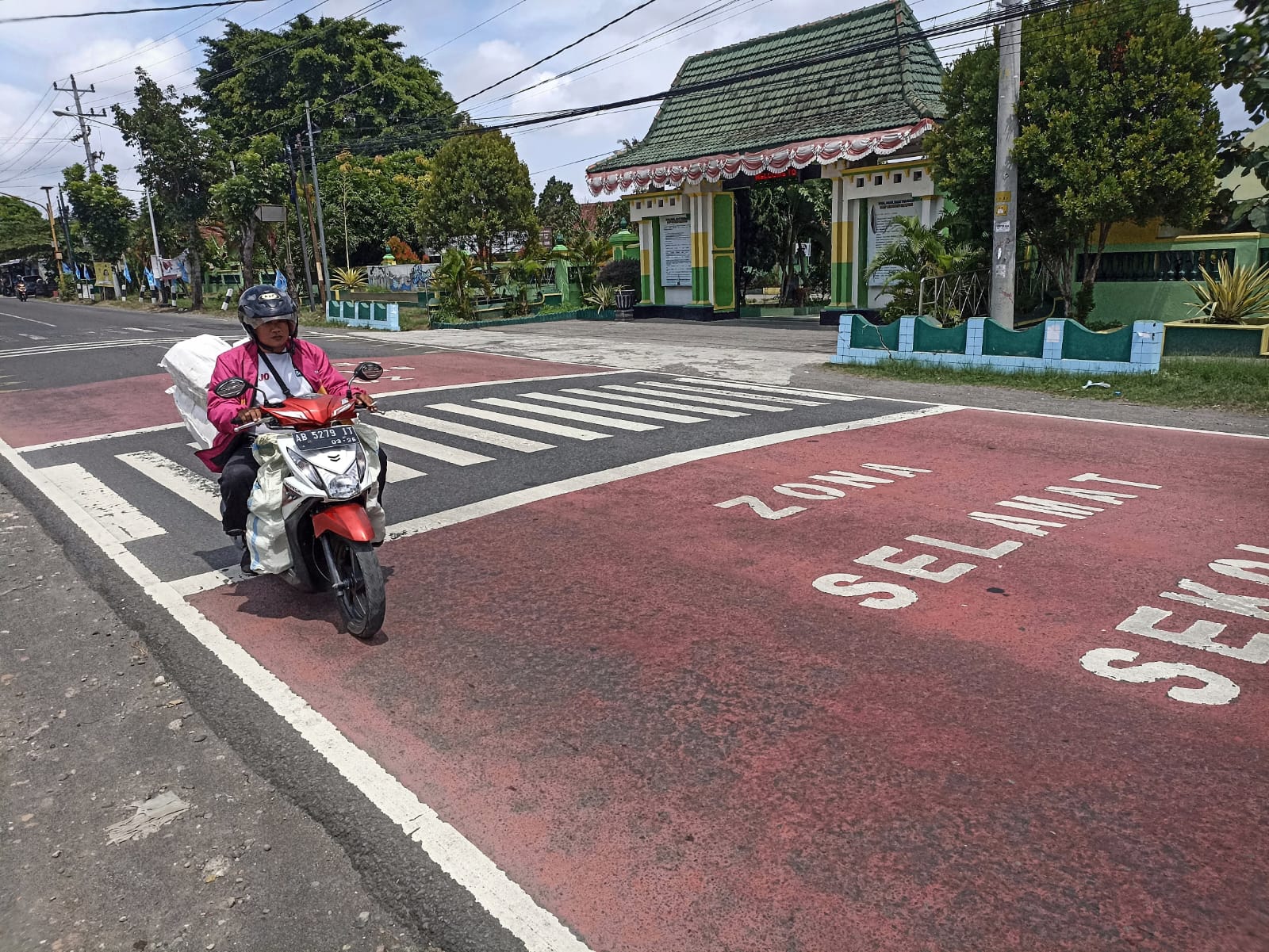 NYAMAN: Pengendara melintasi tanda Zona Selamat Sekolah (Zoss) di depan SMPN 1 Sewon, Bantul, Senin (15/1).