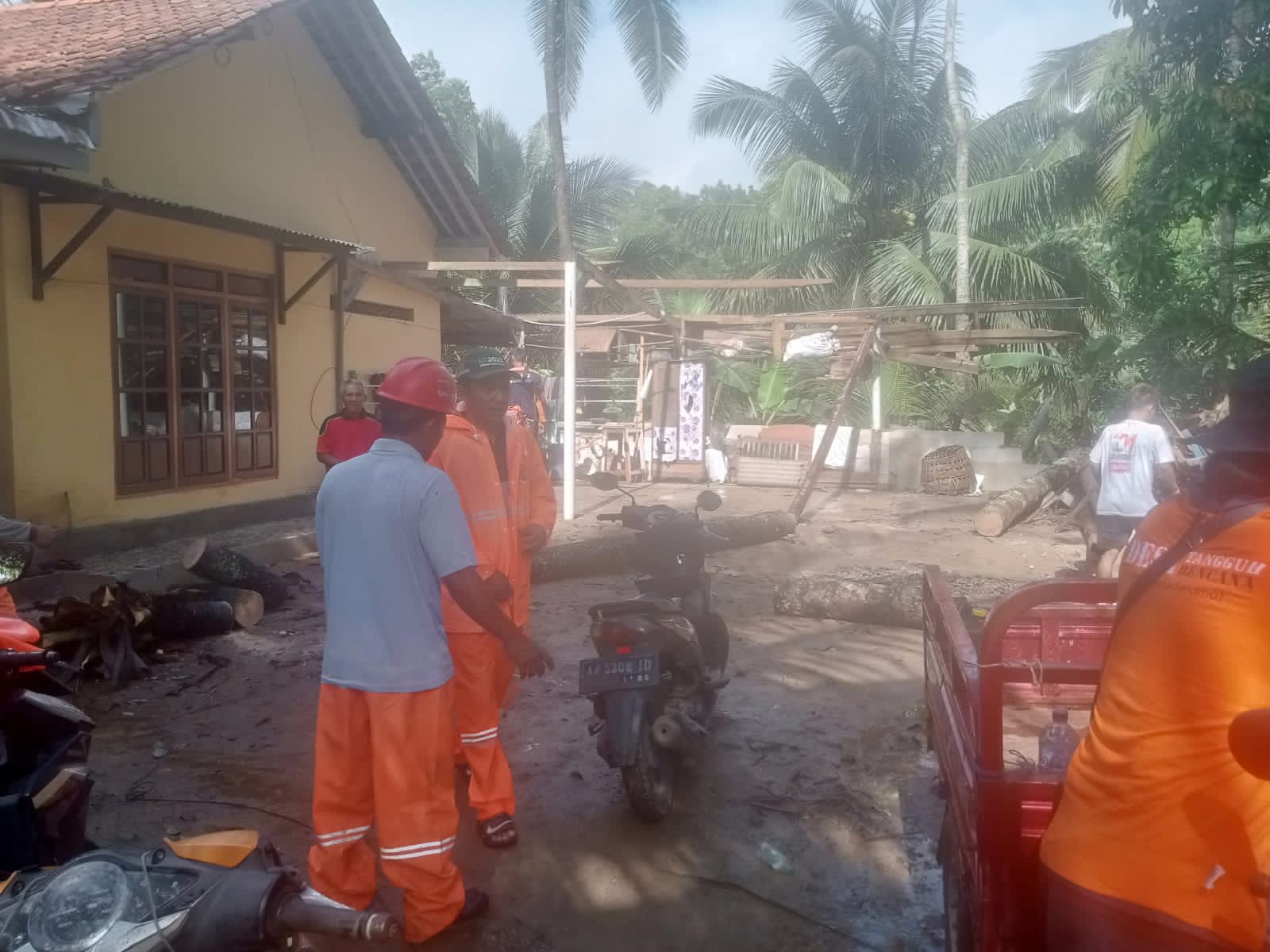 GERAK CEPAT: Petugas BPBD Kebumen bersama warga kerja bakti membersihkan puing rumah yang tertimpa pohon akibat angin kencang.