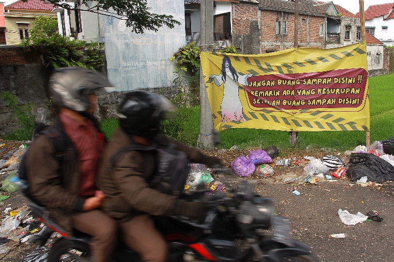 PERINGATAN: Pengguna jalan melintas di dekat tumpukan sampah yang brserakan di jalur lambat Ring Road selatan, kawasan Giwangan, Kota Jogja, beberapa waktu lalu.