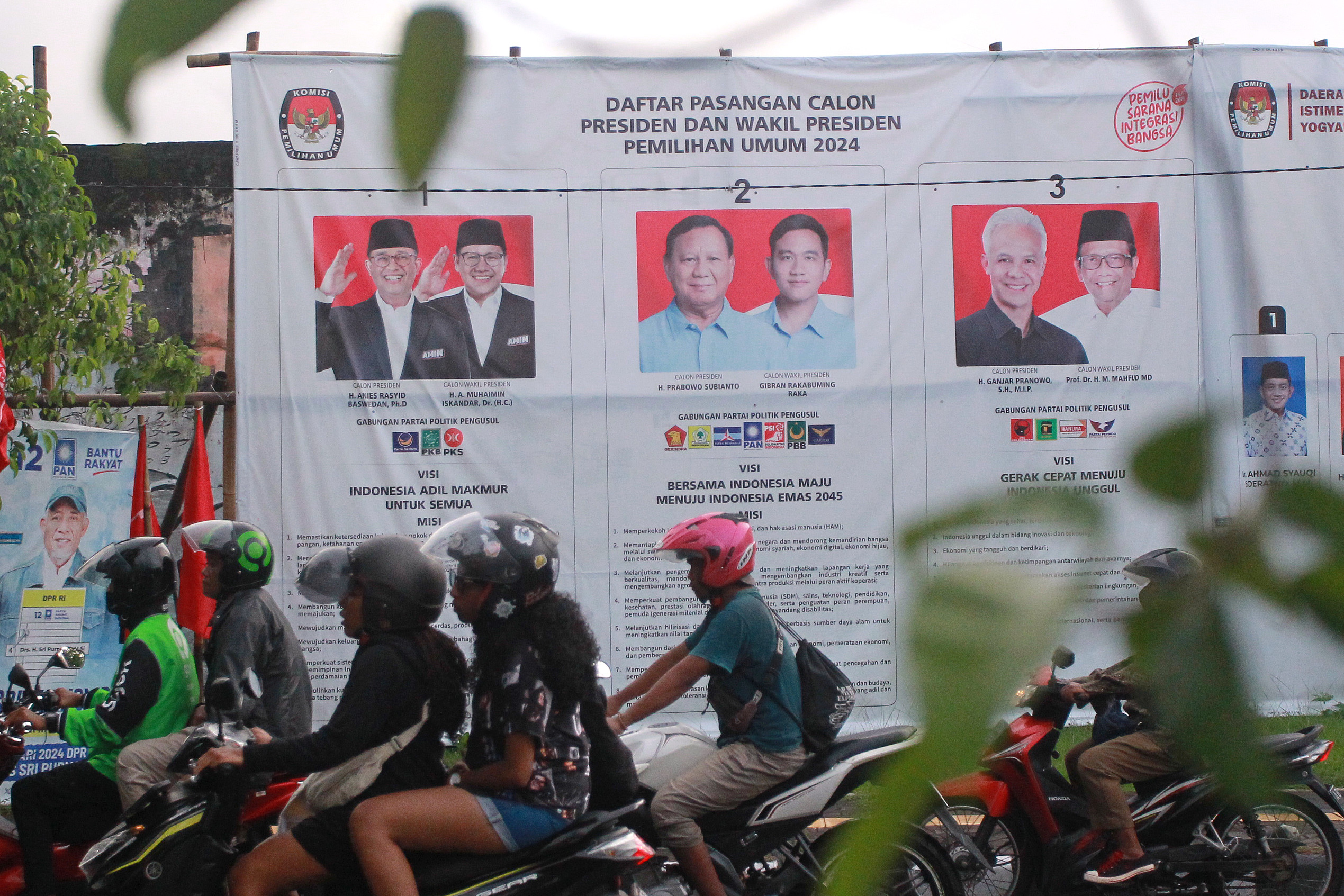 Pengguna jalan melintas di dekat alat peraga sosialisasi visi para pasangan capres dan cawapres, di kawasan Kridosono, Kota Jogja, kemarin (21/1).