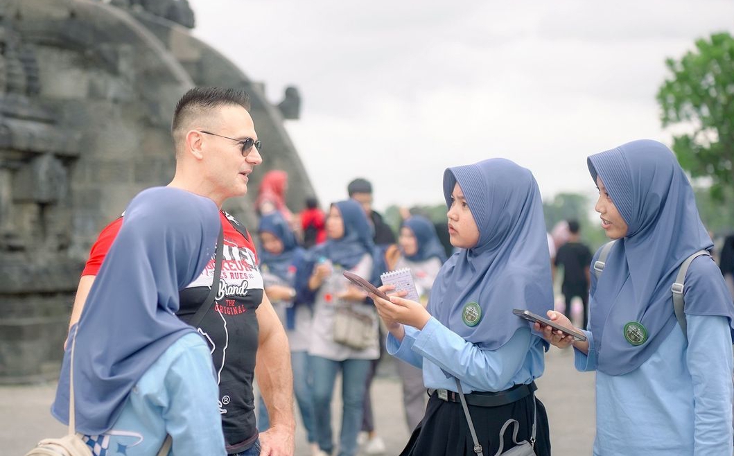PRAKTIK LANGSUNG: Siswa MTs Negeri 1 Kebumen berinteraksi dengan turis asing saat outing class di Candi Prambanan.