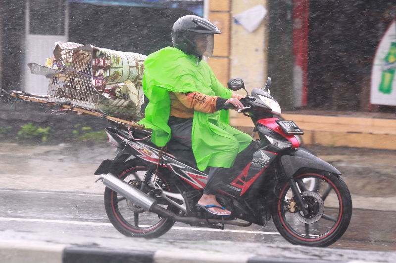 AMAN: Pengendara sepeda motor mengenakan mantol saat turun hujan  di Yogyakarta.