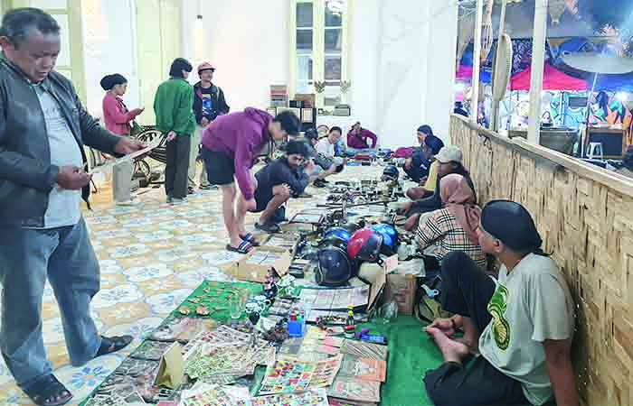 BERBURU LAWASAN: Sejumlah warga tampak melihat-lihat barang lawasan di halaman Loka Budaya Soekimin Adiwiratmoko, Kota Magelang, Sabtu malam (20/1/2024).
