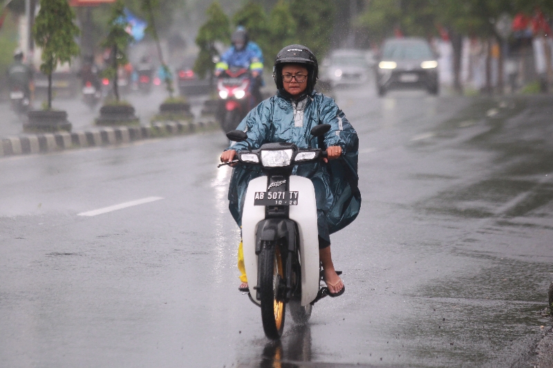LEBAR: Pengendara sepeda motor melaju saat turun hujan di Yogyakarta.