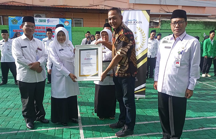 PRESTASI: Direktur Utama Jawa Pos Radar Jogja Ananto Priyatno (baju batik) menyerahkan tanda penghargaan kepada madrasah berprestasi saat apel pagi di Kemenag Kebumen.&nbsp;
