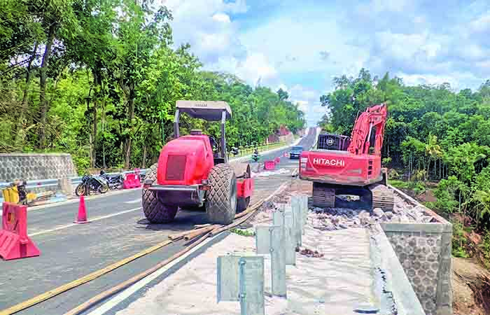 Proses perbaikan ruas jalan Tawang - Ngalang yang amblas di sekitar Jembatan Bobung - Kepil, Patuk, Gunungkidul, Senin (22/1).