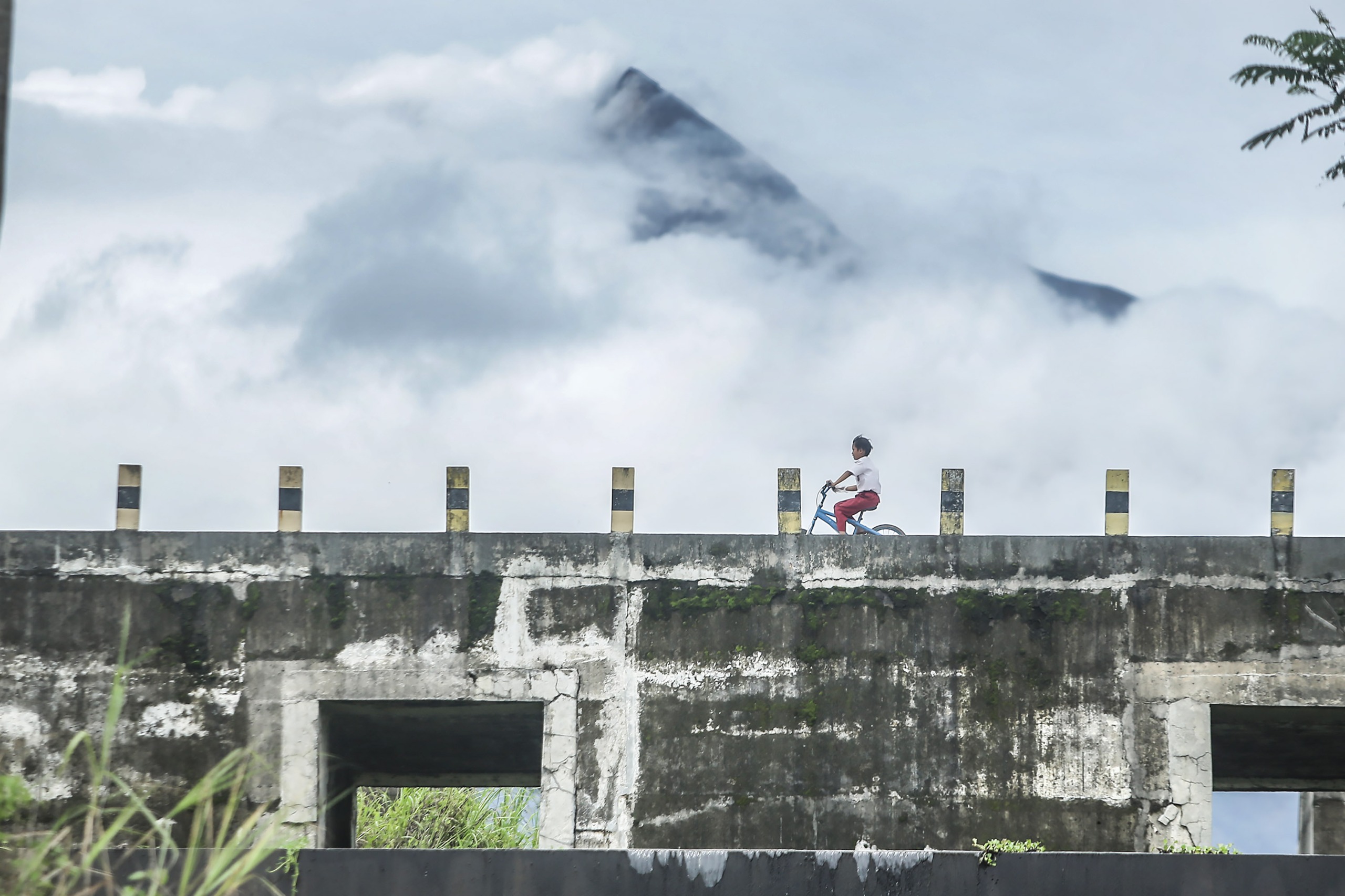 SIAGA: Warga melintas diatas sabo Kali Gendol di kawasan Argomulyo, Cangkringan, Sleman, Selasa (23/1).