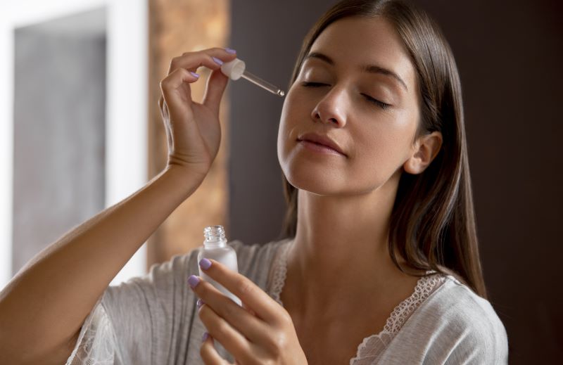 Ilustrasi pemakaian serum retinol pada wajah.