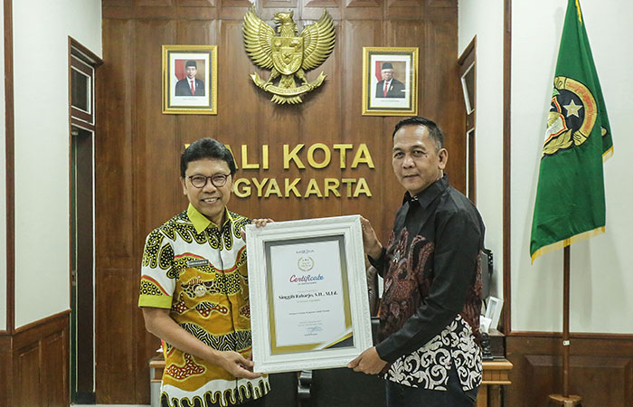 APRESIASI DARI RADAR JOGJA: Direktur Radar Jogja Ananto Priyatno saat memberikan penghargaan  kategori inovasi pelayanan publik kepada Penjabat Wali Kota Jogja Singgih Raharjo di Balai Kota Jogja,