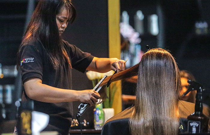 PROSES: Penata rambut di Medua Hair Salon saat mengoleskan krim keratin kepada konsumen kemarin (26/1). Rambut kemudian akan dikeringkan dan dicuci kembali untuk selanjutnya dicatok.