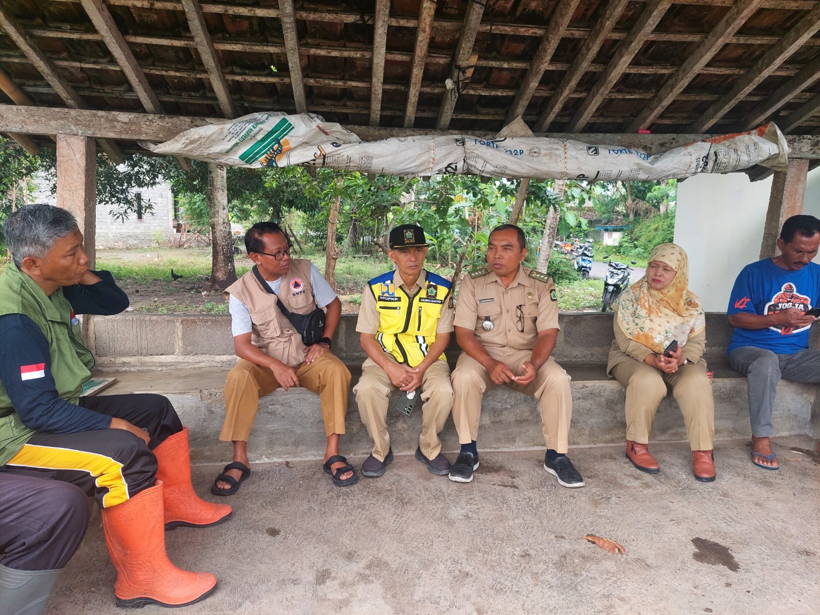 DARURAT: Kepala Pelaksana BPBD Kulon Progo Taufik Prihadi (rompi krem) berdiskusi dengan Kabid Bina Marga DPUPKP Kulon Progo Nurcahyo Budi Wibowo (rompi kuning) di dekat Jembatan Trisik.