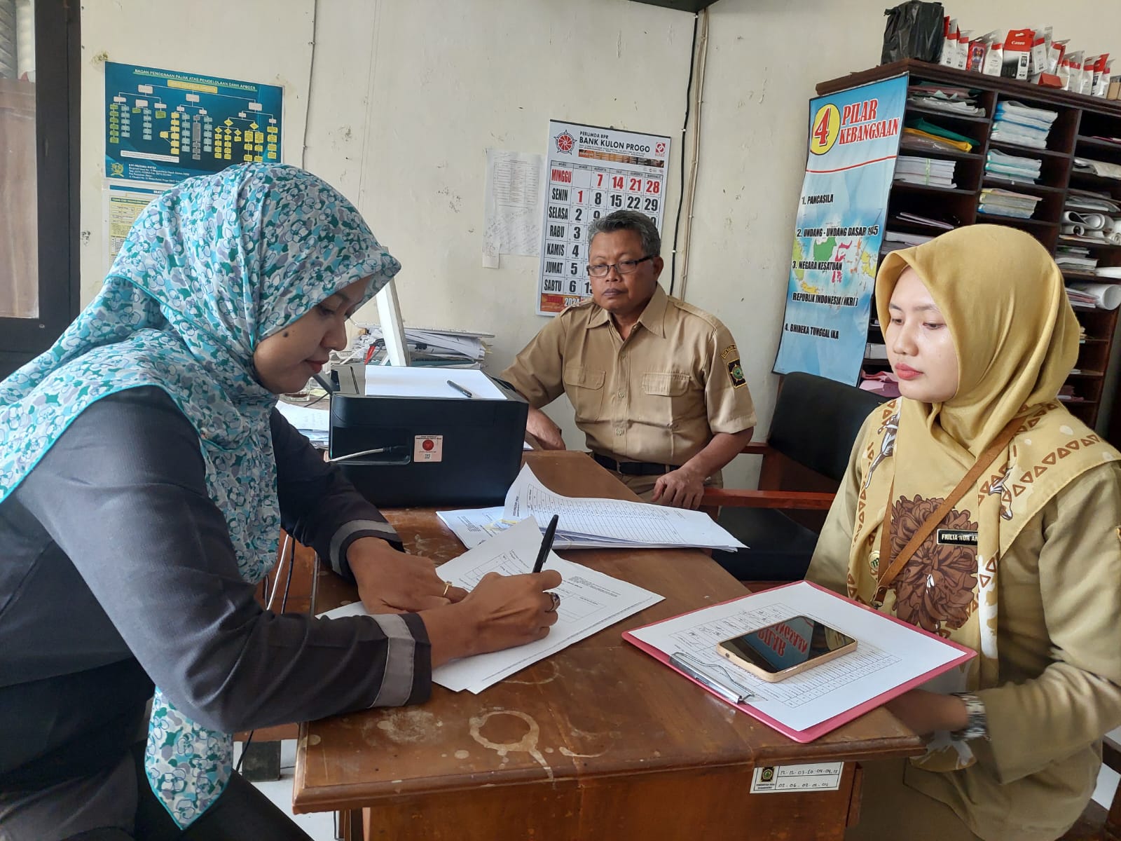 MATUR NUWUN: KPPS TPS 2 Karangsewu Arsih Purnaningsih mengambil uang transport pelantikan di Balai Kalurahan Karangsewu, Kapanewon Galur, Selasa (30/1).