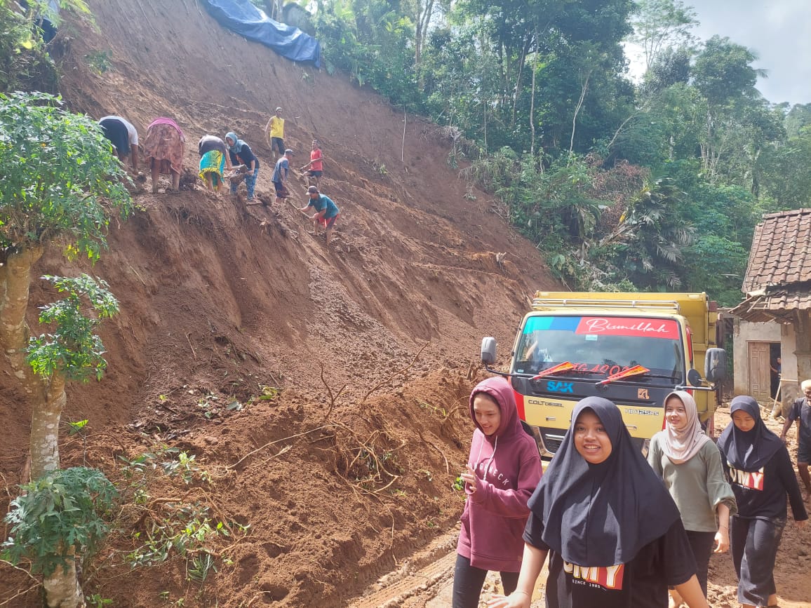 WASPADA: Warga melintas di dekat lokasi longsor di Puncak Suroloyo Kulon Progo.