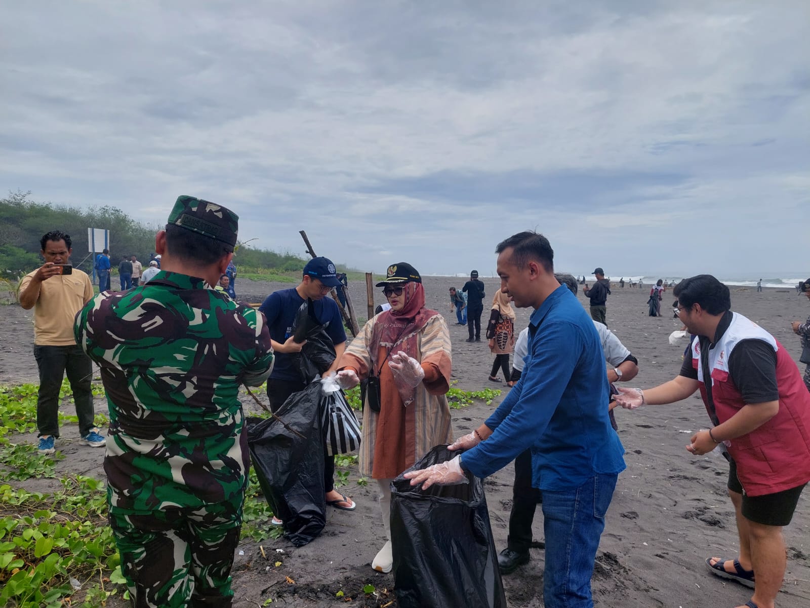 BERSIH: Pj Bupati Ni Made Ni Made Dwipanti Indrayanti didamping TNI AD dan TNI AL melakukan pemungutan sampah saat kegiatan Festival Bersih Congot.
