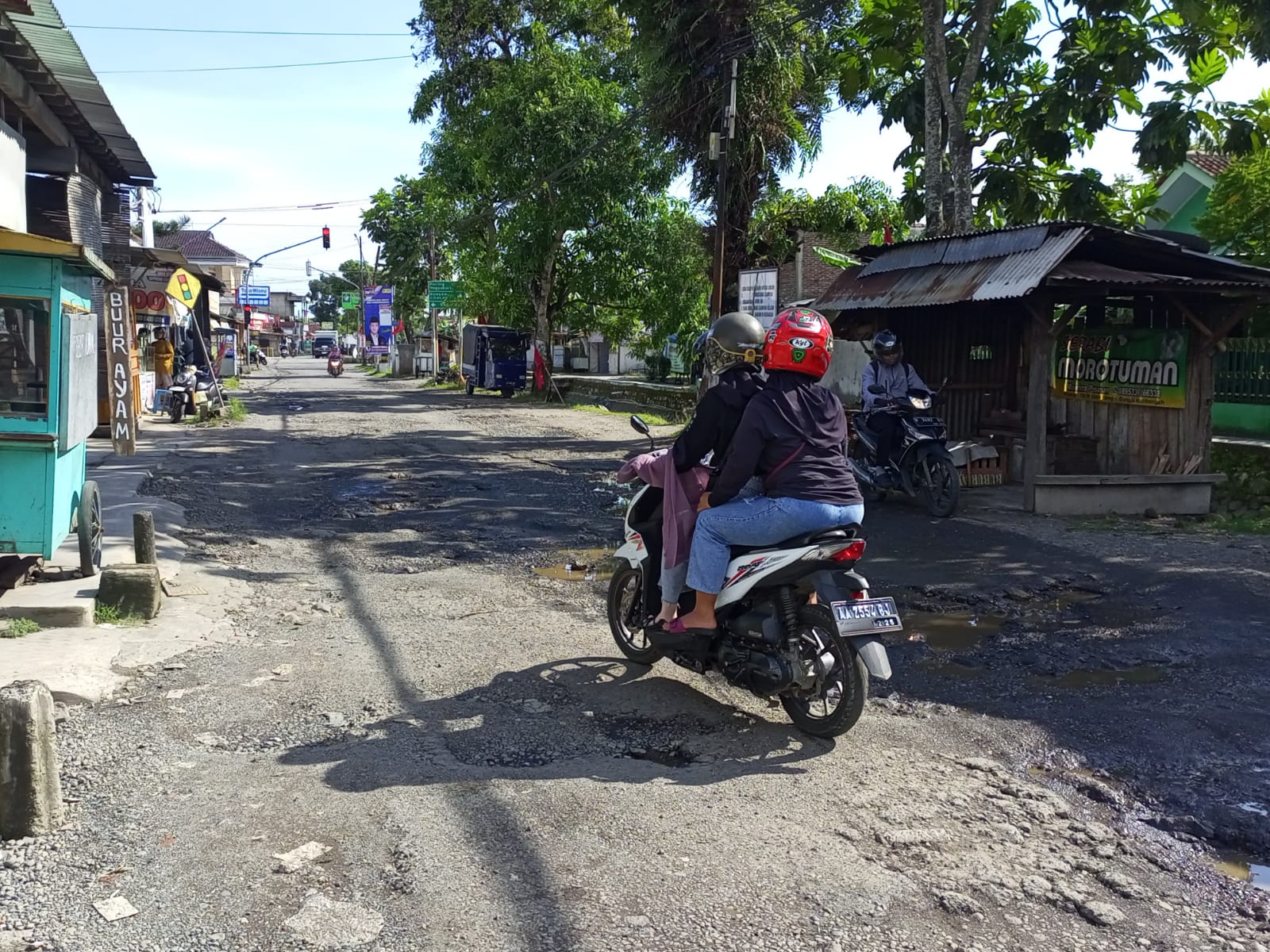 HATI-HATI: Pengendara sepeda motor tampak melewati jalan rusak di utara simpang empat Kalitengah atau ruas Jalan Gombong-Puring.